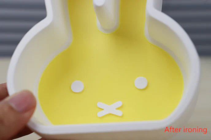 A bunny-shaped yellow 3D-printed model with a smooth and polished surface, showcasing post-ironing finish.
